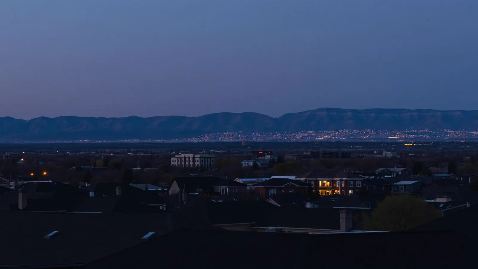 Arvada, Colorado rooftops at dusk with the foothills and Denver metro lights beyond